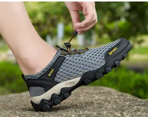 Détail d'une chaussure de sport outdoor en mesh gris respirant avec lacets à serrage.