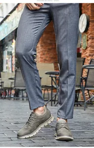 Nahaufnahme von olivgrünen Herren-Brogue-Freizeitschuhen mit dicken Sohlen auf einer Außenstraße.
