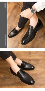 Detailweergave van zwarte herenloafers met krokodillenpatroon en gepolijste afwerking.