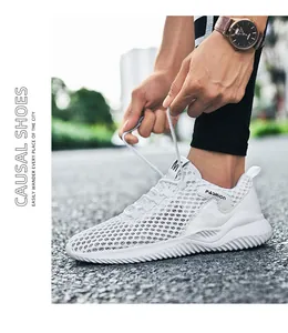 Close-up van witte ademende mesh herensneaker die op straat wordt gestrikt door een man.