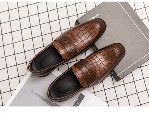 Gedetailleerde weergave van bruine herenleren loafers met krokodillenhuidtextuur