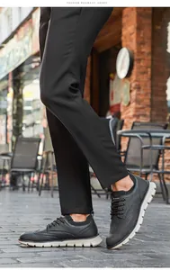 Detailansicht schwarzer Herren-Freizeitschuhe im Brogue-Stil mit dicken Sohlen in der Stadt.