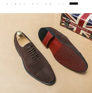 Detail view of men's brown suede cap-toe formal oxford shoes with textured red sole
