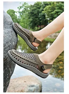 Close-up view of men's woven Roman sandals being worn in a natural outdoor park setting.