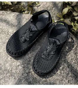 Detailed macro view of black woven men's sandals placed on a natural rock background.