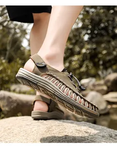 Close-up of men's olive green braided sandals showing cord details in outdoor setting.