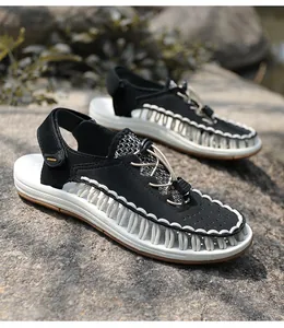 Detail of men's black and white woven sandals on a natural rock background.