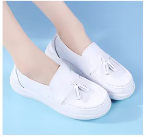Close-up detail of white women's nursing shoes featuring elegant tassels and thick soft soles