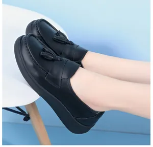 Close-up of black leather platform loafers with tassels, professional nurses' work shoes.
