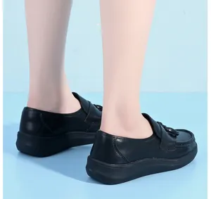 Detailed side view of black leather nurse shoes with thick non-slip soles on feet