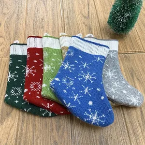 Set van gebreide kerstkousen met witte sneeuwvlokpatronen en handige ophanglussen