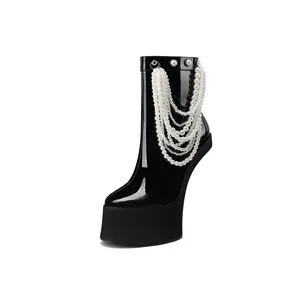 Detailed close-up of a black patent leather platform boot with elegant pearl chains