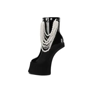 Side view of black patent leather platform boots with elegant layered pearl chains