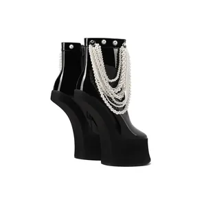 Detailed side view of black patent leather platform boots with elegant pearl chain accents