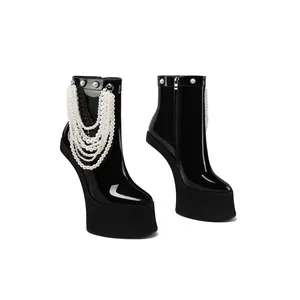 Macro view of black patent leather heelless platform boots with layered pearl chains