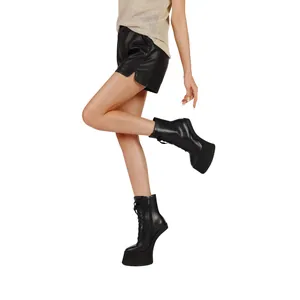 Close-up of women's black lace-up platform ankle boots with a unique heel-less design