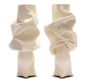 Vista trasera de botas slouchy color crema con tacones de cuña esculturales