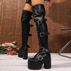 Close-up of punk style over-the-knee boots with multi-buckle straps and platform heel.