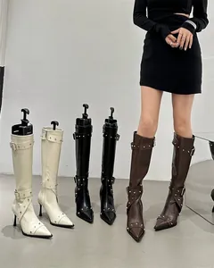 Detail view of stylish pointed toe stiletto boots with rivet buckle straps in multi colors