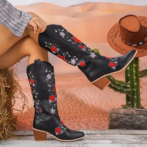 Dettaglio del ricamo floreale squisito su eleganti stivali da cowboy neri medi