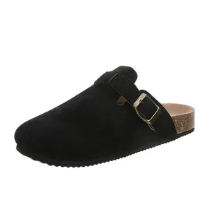 Detailansicht der schwarzen Wildleder-Clogs mit verstellbarer Schnalle und Korksohle.