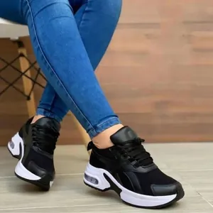 Modieuze zwarte damessneakers met meshpanelen en witte zolen met luchtkussens.