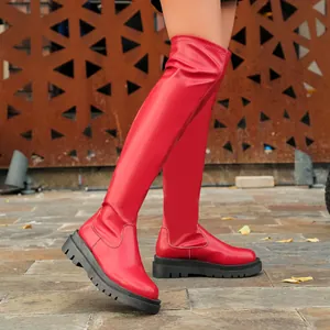 Vista laterale di stivali cuissard elasticizzati rosso vivace con suola platform nera