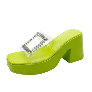 Macro view of lime green platform slide sandal featuring rhinestone buckle and clear strap