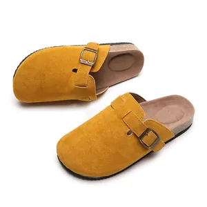 Detailansicht von gelben Wildleder-Clogs mit Korksohle und verstellbarem Metallschnallenriemen