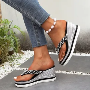 Detail van dames slippers met sleehak en bandjes met parels en strass steentjes.