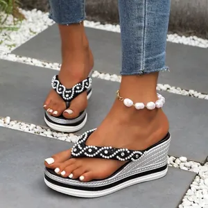 Detailweergave van de wedge slippers met strass steentjes en elegante parel enkelband.