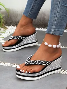 Detailopname van dames sandalen met sleehak, strass-bandjes en een zilveren plateau.