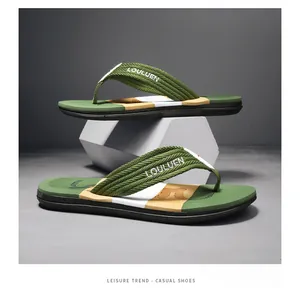 Detailaufnahme von Herren-Flip-Flops mit grünen gewebten Riemen für den Sommer am Strand.