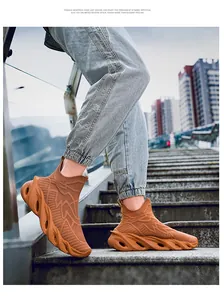 Gros plan de baskets montantes marron avec semelle à lame et tige en tricot sur escalier