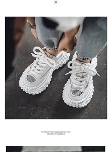 Dettaglio di sneaker bianche traspiranti con suola spessa a forma di pneumatico.