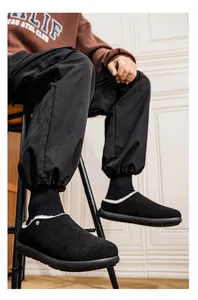Primo piano di pantofole invernali da uomo con fodera in pile bianco e design nero
