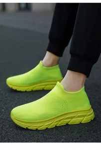 Vista lateral de zapatillas de punto amarillo neón sin cordones para hombre