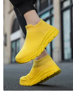 Vista lateral de zapatillas tipo calcetín amarillo brillante en movimiento dinámico.
