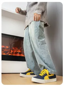 Detailweergave van marineblauwe en gele retro canvas sneakers met een lichte baggy jeans.