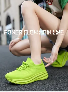 Close-up van neon groene mesh sneakers op asfalt met een stedelijke street style.