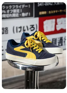 Detailopname van marineblauwe en gele skateschoenen met warme voering en dikke rubberen zool.