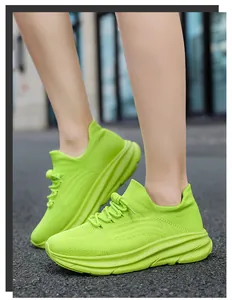 Gedetailleerd zijaanzicht van fel neon groene chunky gebreide sneakers op de straat