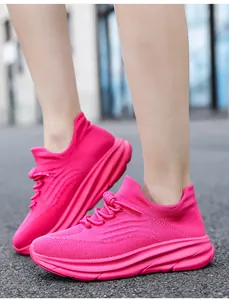 Detailweergave van felle roze chunky sneakers met opvallende dikke golvende zolen.