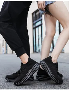 Gedetailleerd close-up van zwarte ademende sneakers met dikke zool op een buitenstraat.