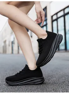 Detailopname van stijlvolle zwarte ademende mesh sportsneakers met dikke zolen op model