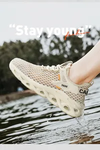 Close-up of men's breathable mesh running shoes in an outdoor water setting.