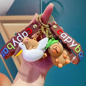 Schattige capibara siliconen sleutelhangers met kleurrijke band gehouden in de hand.
