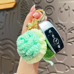 Handmade crochet flower keychain with green knit petals and gold bell