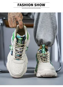 Detail view of trendy beige men's sports shoes with chunky soles and green accents