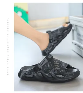 Detaillierte Seitenansicht der schwarzen Graffiti-Clogs mit dicker, gepolsterter Sohle.